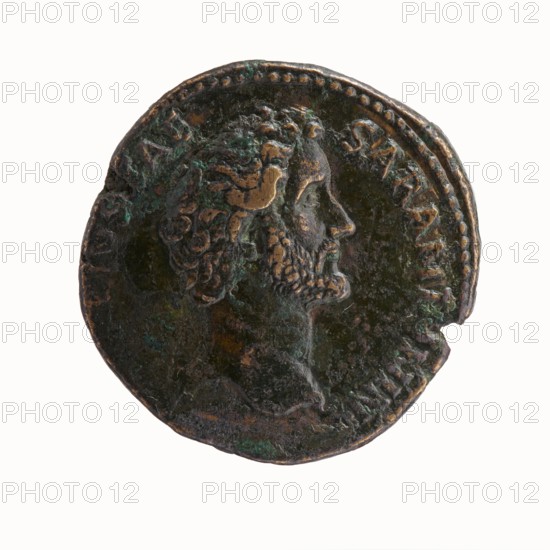 Dupondius/as, Hadrian 76–138; Roman emperor 117–138 issuer, Antoninus Pius 86–161; Roman emperor 138–161 caesar 138. Obverse: Head of Antoninus Pius without a covering to the right, legend IMP TAELIVS CAE - SAR ANTONINVS all around. Reverse: Pietas standing left in front of an altar, making an offering with his right hand and holding a container with perfumes in his left hand; legend TRIB POT COS DES II all around, in the episode PIETAS. Date: 138. Place of origin: Rome, Roman Empire. Object: coin dupondius/as. Dimensions: diameter 25.5–26.0 mm, weight 14.16 g, axis 165°., A circular metal coin with a worn, textured surface showing a raised profile of a bearded man facing right, his hair and beard rendered in curls; the coin has areas of dark brown, greenish patina, and some lighter bronze highlights, with a slightly irregular rim and a small chunk missing at one edge.
