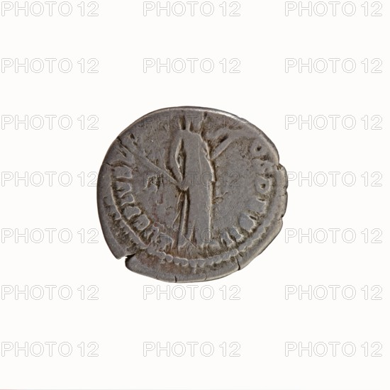 Denarius, Antoninus Pius 86–161; Roman emperor 138–161. Obverse: Head of Antoninus Pius uncovered to the right, legend IMP T AEL CAES HADRI - ANTONINVS. Reverse: Diana standing to the right, holding a bow in her outstretched left hand and an arrow in her lowered right hand, legend AVG PIVS PM TR PC - OS DES II. Iconography: ancient deities; standing Diana; bows; arrows. Date: 138. Place of origin: Rome, Roman Empire. Medium/type: coin. Measurements: diameter 16.5–18.0 mm, weight 2.78 g, axis 195°., A worn round metallic object with a grey and brown patina, showing a raised central figure draped in a long garment and holding a staff, surrounded by a circular border and subtle raised markings, with small chips and cracks along the edges and uneven surface texture.