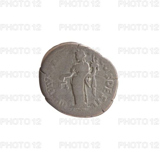 Denarius of Antoninus Pius 86–161; Roman emperor 138–161. Obverse: head of Antoninus Pius uncovered to the right; inscription IMP TAE L CAES HA DRI ANTONINVS all around. Reverse: Aequitas standing to the left, holding scales in his outstretched right hand and a cornucopia in his left; inscription AVG PIVS PM T R P COS DES II all around. Iconography: personifications; Aequitas with scales and cornucopia. Date: 138. Place: Rome, Roman Empire. Object type: coin denarius. Diameter: 15.0–19.5 mm; weight: 2.80 g; axis: 165°., A round coin with a worn surface showing a raised outline of a standing human figure and a smaller raised shape near the figure, all in shades of gray and silver with areas of darker gray patina and slight brownish tones along the edge.