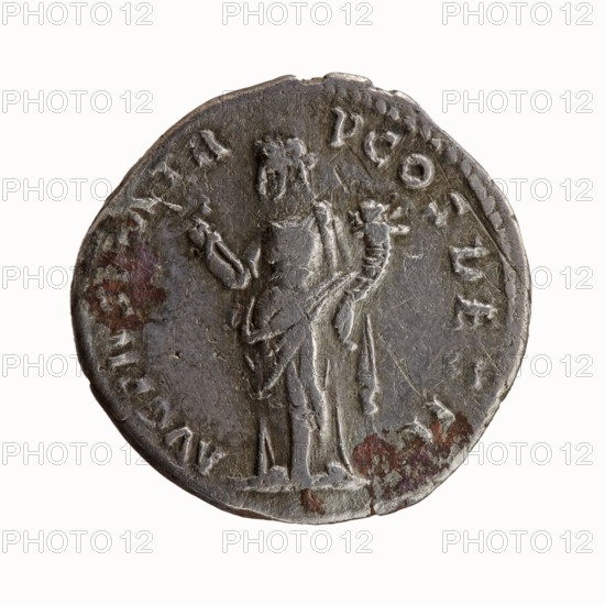Denarius, Antoninus Pius 86–161; Roman emperor 138–161, issuer. Obverse: Head of Antoninus Pius uncovered to right, legend IMP T AEL CAES HADRI - ANTONINVS around. Reverse: Felicitas standing left, holding a caduceus in his outstretched right hand and a horn of plenty in his left, legend AVG PIVS PM TR - P COS DES II around. Iconography: caducei; personifications; horns of plenty; Felicitas standing with a caduceus and a horn of plenty. Date: 138. Place of origin: Rome, Roman Empire. Medium: coin denarius. Diameter: 16.0–17.0 mm. Weight: 2.95 g. Axis: 180°., A circular metal object with a worn, uneven edge showing a few small nicks and chips, featuring a raised depiction of a standing robed figure seen from behind and slightly to the side, holding an object in one hand and a curved, ornate item in the other; the surface is textured with scratches and pits and shows patches of darker and reddish-brown discoloration alongside areas of dull gray and silvery tones, with faint raised markin...