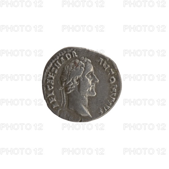 Denarius, Antoninus Pius 86–161; Roman emperor 138–161. Obverse: head of Antoninus Pius in a laurel wreath to the right, legend IMP T AEL CAES HADR - ANTONINVS. Reverse: Fortuna standing left, holding a rudder resting on a globe in her right hand and a cornucopia in her left, legend AVG PIVSPM - TR - P COS II. Iconography: Fortuna, rudder, cornucopia horn of plenty, personification. Date: 139. Rome, Roman Empire. Coin; diameter 16.5–18.0 mm; weight 2.99 g; axis 180°., A circular metallic object with a worn surface showing a raised profile of a person's head facing right, with short wavy hair and a beard, surrounded by faint raised markings along the rim; the object appears gray-silver with darker gray shading in recessed areas and slight brownish discoloration in a few spots.