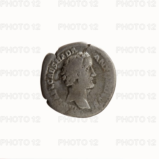 Denarius, Antoninus Pius 86–161; Roman emperor 138–161. Obverse: Head of Antoninus Pius uncovered facing right, legend IMP T AEL CAES HADR ANTONINVS. Reverse: Two hands clasping and holding a winged caduceus, legend AVG PIVS PM TR P COS II. Date: 139. Place: Rome. Type: coin denarius. Diameter: 17.5–18.0 mm. Weight: 3.20 g. Axis: 165°., A round metal coin with a worn surface showing a raised profile of a man's head facing right, with short curly hair and a visible neck and shoulder; the coin's edge is irregular with a few nicks and chips, and the surface shows scratches and patches of darker tarnish; colors visible include silver-gray metal tones with areas of darker gray and slight brownish spots.