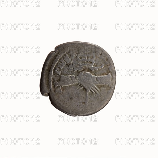 Denarius, Antoninus Pius 86–161; Roman emperor 138–161. Obverse: Head of Antoninus Pius uncovered facing right, legend IMP T AEL CAES HADR–ANTONINVS. Reverse: Two hands clasping and holding a winged caduceus, legend AVG PIVS PM TR P COS II. Date: 139. Place: Rome, Roman Empire. Coin; diameter 17.5–18.0 mm, weight 3.20 g, axis 165°., A round metallic object with a worn surface in shades of gray and muted silver sits against a white background; the object shows irregular edges and a slightly darker crescent area on one side, and its surface bears shallow incised shapes including an arm-like form and a hand-like shape, along with curved and linear indents and faint textured marks.
