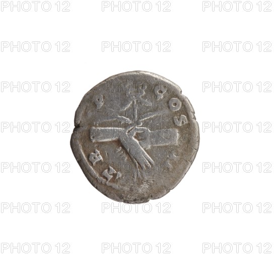 Denarius, Antoninus Pius 86–161; Roman emperor 138–161. Obverse: Head of Antoninus Pius in a laurel wreath facing right, legend ANTONINVS • AVG • PIVS • PP. Reverse: Two hands clasped together holding a winged caduceus and ears of corn, legend TR • P • COS • II. Iconography: hands joined on a caduceus and ears of corn agreement/symbol. Roman, 139. Mint: Rome. Coin; diameter 17.0–18.0 mm; weight 2.70 g; axis 165°., A single round metallic object is centered against a plain white background, showing a worn surface with irregular edges and a slightly raised rim. The object appears mostly gray with darker gray and brownish tones in the recessed areas, and lighter silvery highlights on the raised portions. The surface shows a central raised design consisting of intersecting flat shapes and lines, with a few small raised marks and shallow scratches scattered across the face. The overall texture looks rough and uneven, with areas of slight discoloration and patina.