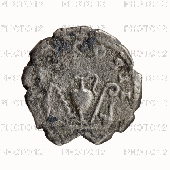 Denarius, Antoninus Pius 86–161; Roman emperor 138–161 issuer. Obverse: Head of Antoninus Pius without a cover to the right; legend ANTONINVS AVG PIVS P P. Reverse: Sacred implements from the left—aspergillum, jug capis, crosier staff lituus, and scoop simpulum; legend TR P COS II. Date: 139. Place of origin: Rome, Roman Empire. Coin type: silver denarius. Diameter: 18.0–18.5 mm. Weight: 2.51 g. Axis: 180°., A round, irregularly edged object with a rough, pitted surface in shades of gray and dark gray, showing a raised central area with a few curving, embossed shapes that include a rounded form and a couple of hooked or spiral lines; the object has uneven, scalloped margins and variations in texture that create lighter gray highlights and darker gray shadows across its surface.