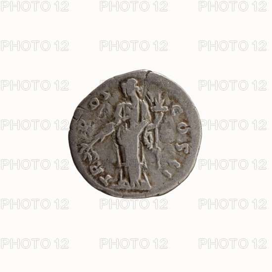 Denarius, Antoninus Pius 86–161; Roman emperor 138–161. Obverse: Head of Antoninus Pius uncovered to the right, legend ANTONINVS·AVG·PIVS·PP. Reverse: Pax standing left, holding a branch in his right hand and a cornucopia in his left, legend TR·POT·COS·II. Iconography: Pax with branch and cornucopia; branches; personifications; cornucopias. Date: 139. Place of manufacture: Rome, Roman Empire. Type: coin denarius. Diameter: 17.0–17.5 mm. Weight: 2.67 g. Axis: 180°., A round, weathered coin colored gray with darker and lighter gray variations features a raised, worn relief of a standing human figure holding an object in one hand and a stem-like shape in the other; the figure and surrounding relief appear textured and eroded, with irregular edges and a small crack near the top of the coin, and a ring of shallow, worn symbols or marks encircles the central figure.