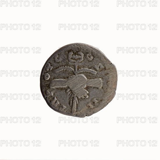 Denarius of Antoninus Pius 86–161; Roman emperor 138–161. Obverse: Head of Antoninus Pius in a laurel wreath facing right, legend ANTONINVS · AVG · PIVS · PP. Reverse: Two hands clasping, holding a winged caduceus and ears of corn, legend TR P · OT C · OS · II. Iconography: hands holding a caduceus, ears of corn, consent symbol. Roman, Rome, 139. Coin. Diameter 17.0–18.0 mm, weight 3.26 g, axis 180°., A round, worn metal coin with a gray-brown patina showing a raised central design that resembles a stylized plant or floral motif with a stem and curved elements, surrounded by a few irregular marks and shallow scratches; the coin's edge is uneven with a small notch and several fine abrasions, and the surface displays areas of lighter and darker gray mixed with brown tones.