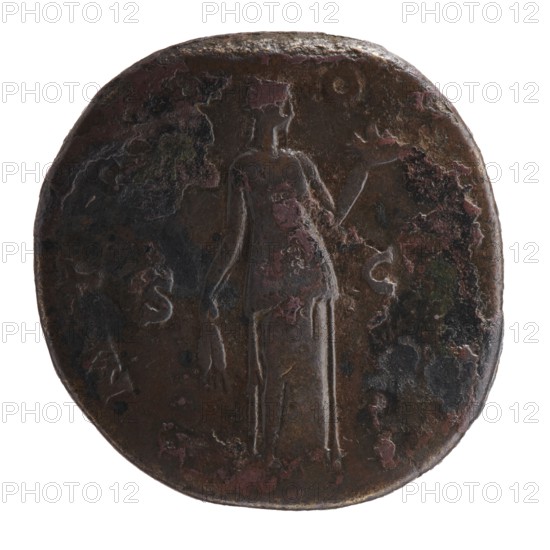 Sestertius of Antoninus Pius 86–161; Roman emperor 138–161. Obverse: head of Antoninus Pius in a laurel wreath to the right; inscription IMP T AEL CAES HADR ANTO - NINVS AVG PIVS PP. Reverse: Fides standing frontally, head turned right; in outstretched left hand a bowl of fruit, in lowered right hand ears of corn; inscription P MTRP - OT COSII, in SC fields. Date: 139. Place of origin: Rome, Roman Empire. Coin; diameter 31.5–32.0 mm, weight 27.27 g, axis 165°., A round, worn coin with a dark brown surface and patches of reddish and greenish discoloration shows a faint raised figure of a standing person in the center holding an object in each hand; the figure is slightly lighter in tone than the surrounding metal. The coin edge is irregular and darker, with areas of rough texture and mottled spots of black and pinkish-red. The background around the figure has uneven dark brown and black areas with scattered small splotches of reddish and green. The overall appearance is aged and corrode...