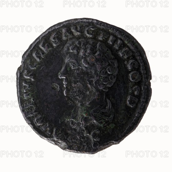 Head of Antoninus Pius with laurel wreath to the right, legend ANTONINVS - AVG PIVS PP around; reverse: Bust of young Marcus Aurelius, in cloak paludamentum and uncovered to the left, legend AVRELIVS CAES AVG PII F COS DES all around, under the portrait SC., 139 CE, Roman Empire, Rome; coin; diameter 29.0 mm and 29.5 mm, weight 12.95 g, axis 180°. Includes iconography of Antoninus Pius and Marcus Aurelius, portraits heads, paludamentums. Makers: Antoninus Pius 86–161; Roman emperor 138–161 and Marcus Aurelius 121–180; Roman emperor 161–180; caesar 139–161; heir to the throne 138–161., A round, worn coin with a dark, mottled surface showing a raised profile of a person facing left; the profile includes a detailed curly hairstyle and a visible ear and nose, and the coin edge features a raised rim with a repeating decorative pattern. The surface shows irregular textures and patina with visible patches of green and hints of brown on a mainly dark gray to black background, and the coin appe...