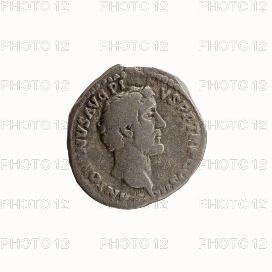 Denarius, Antoninus Pius 86–161; Roman emperor 138–161 — issuer; Marcus Aurelius 121–180; Roman emperor 161–180 — caesar 139–161, heir to the throne 138–161. Iconography: heads portraits. Obverse: Head of Antoninus Pius without a covering to the right, legend ANTONINVS AVG PI-VS PP TR P COS III around. Reverse: Head of young Marcus Aurelius without a covering to the right, legend AVRELIVS CAESAR AVG PII F COS around. Date: 140. Place of origin: Rome, Roman Empire. Medium: coin denarius. Diameter: 17.0–18.0 mm. Weight: 3.02 g. Axis: 180°., A round metallic object with a worn surface showing a raised profile of a man's head in right-facing profile, with short hair and a short beard, surrounded by an outer raised rim and a band of irregular raised marks; the object appears gray and tarnished with darker gray areas and lighter silvery highlights, and shows an uneven edge and small surface pits and scratches.