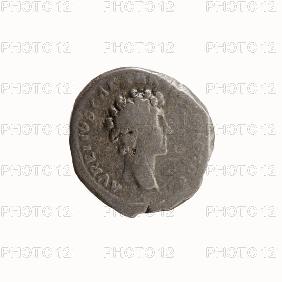 Denarius, Antoninus Pius 86–161; Roman emperor 138–161. Obverse: head of Antoninus Pius without a covering to the right, inscription ANTONINVS AVG PIVS PP TR P COS III. Reverse: head of young Marcus Aurelius without a covering to the right, inscription AVRELIVS CAESAR AVG PII F COS. Date: 140. Place of minting: Rome, Roman Empire. Material: coin. Diameter: 17.0–18.0 mm. Weight: 3.02 g. Axis: 180°., A single round coin with an uneven edge shown against a plain white background, the coin appears metallic and gray with darker and lighter areas, featuring a worn profile of a person facing right with textured hair and a visible neck and shoulder, and the coin surface shows scratches, dents, and small irregularities.
