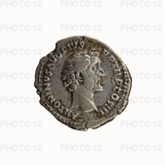 Denarius, Antoninus Pius 86–161; Roman emperor 138–161 issuer; Marcus Aurelius 121–180; Roman emperor 161–180 caesar 139–161; Marcus Aurelius heir to the throne 138–161 — iconography: obverse: Head of Antoninus Pius, bare, right, legend ANTONINVS AVG PIVS - PP TR P COS III; reverse: Bust of young Marcus Aurelius in cloak paludamentum, bareheaded, right, legend AVRELIVS CAES - AVG PII F COS; dated 140; Roman Empire; Rome mint; coin; diameter obv. 17.0 mm, rev. 18.5 mm; weight 3.27 g; axis 195°., A worn round metal coin with an uneven rim showing signs of age and small chips, featuring a raised profile of a person facing right with short curly hair and facial hair; the coin's surface is textured with scratches and patches of darker and lighter areas, and the visible colors are silver-gray with hints of brown and darker tarnish.