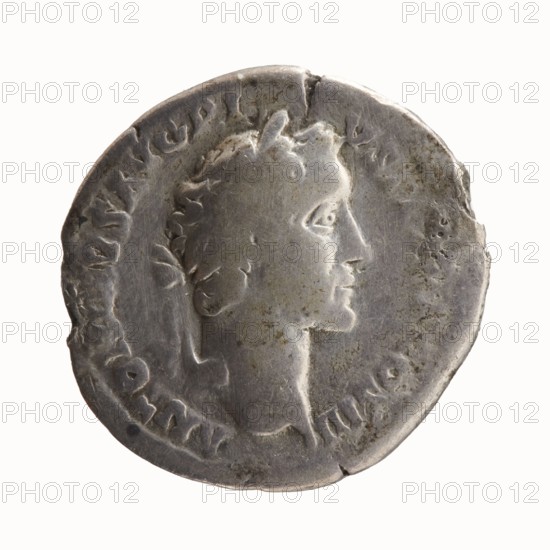 Denarius, Antoninus Pius 86–161; Roman emperor 138–161 issuer; Marcus Aurelius 121–180; Roman emperor 161–180 caesar 139–161; Marcus Aurelius heir to the throne 138–161 — iconography. Antoninus Pius — iconography. Heads portraits. Obverse: Head of Antoninus Pius with laurel wreath facing right, legend ANTONINVS AVG PI•VS PPTR P COS III. Reverse: Head of young Marcus Aurelius without covers right, legend AVRELIVS CAE•SAR AVG PII F COS. Date: 140. Place of origin: Rome, Roman Empire. Object type: coin denarius. Diameter: 16.0 mm and 18.5 mm. Weight: 2.78 g. Axis: 225°., A round metallic coin displaying a worn raised profile of a person facing right, with short stylized hair and a defined nose and chin, set against a slightly mottled background; the coin shows uneven edges with small chips and dents and areas of surface darkening and spotting; visible colors include silver, gray, darker gray, and small patches of brownish discoloration.
