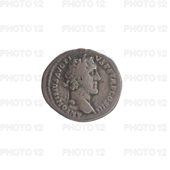 Denarius, Antoninus Pius 86–161; Roman emperor 138–161. Obverse: Head of Antoninus Pius with laurel wreath to the right, legend ANTONINVS AVG PI - VS PP TR P COS III. Reverse: Head of young Marcus Aurelius without a covering to the right, legend AVRELIVS CAESAR AVG PII F COS. Date: 140. Place of origin: Rome, Roman Empire. Medium: coin denarius. Diameter: 16.0–17.0 mm. Weight: 2.94 g. Axis: 210°., A round metallic object with a worn surface showing the profile of a person facing right, surrounded by raised edges and a ring of shallow markings; the object appears mostly gray with darker and lighter gray variations and subtle brownish tones.