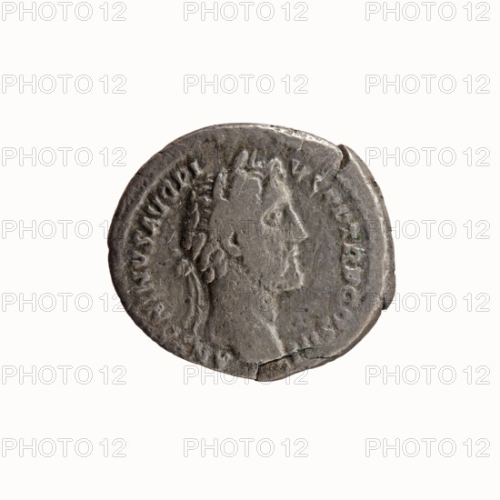 Denarius, Antoninus Pius 86–161; Roman emperor 138–161. Obverse: Head of Antoninus Pius in laurel wreath to the right, legend ANTONINVS AVG PI - VS PP TR P COS III. Reverse: Bust of young Marcus Aurelius in cloak paludamentum, without headgear, right, legend AVRELIVS CAESAR AVG PII F COS. Date: 140. Culture/place: Roman Empire, Rome. Medium: coin. Diameter: 17.0–19.0 mm. Weight: 2.74 g. Axis: 180°., A round metallic object with a weathered, uneven surface showing a raised profile of a person's head facing right, with textured hair and facial features visible; the object has worn edges, a few chips and small cracks, and faint circular raised decorations around the perimeter. The visible colors are shades of gray and silver with some darker gray areas and subtle greenish patina in spots.