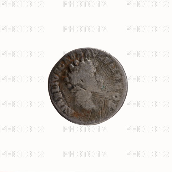 Denarius, Antoninus Pius 86–161; Roman emperor 138–161 issuer Marcus Aurelius 121–180; Roman emperor 161–180 caesar 139–161. Obverse: Head of Antoninus Pius with laurel wreath facing right, legend ANTONINVS AVG - PIVS PP TR P COS III. Reverse: Bust of young Marcus Aurelius in cloak paludamentum, without headgear, facing right, legend AVRELIVS CAES AVG PII F COS. Iconography: heads portraits, paludamentums. Date: 140. Place of manufacture: Rome, Roman Empire. Object type: coin denarius. Diameter: 17.0–17.5 mm. Weight: 2.73 g. Axis: 195°., A worn round metal coin with a rough textured surface showing scratches and pits, primarily dark gray with patches of brownish rust and a small area of greenish discoloration, featuring an indistinct raised profile of a head and a rim with faint raised markings, photographed against a plain white background.