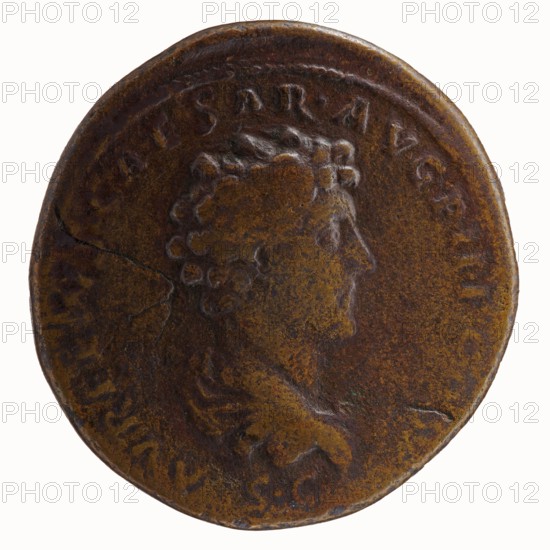 Sestertius, Antoninus Pius 86–161; Roman emperor 138–161. Obverse: Head of Antoninus Pius in a laurel wreath to the right, legend ANTONINVS AVG PI - VS PP TR P COS III around. Reverse: Bust of young Marcus Aurelius in cloak paludamentum, without headgear, right, legend AVRELIVS CAESAR AVG PII F COS around, below portrait SC. Date: 140–144. Roman Empire; Rome. Coin; diameter 32.5–34.0 mm; weight 21.15 g; axis 0°. Iconography: Antoninus Pius and Marcus Aurelius; heads portraits; paludamentums., A worn circular metal coin with a raised profile of a person's head facing right, showing curly hair and a partial suggestion of a neck and shoulders, all in shades of brown and dark bronze with areas of darker patina and lighter golden-brown highlights; the rim is slightly irregular and darker, and there are subtle surface scratches, a faint crack, and mottled spots of darker brown and greenish discoloration across the face of the coin.