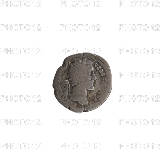 Denarius of Antoninus Pius 86–161; Roman emperor 138–161. Obverse: head of Antoninus Pius in a laurel wreath facing right, legend ANTONINVSAVG PI-VS PP TR P COS III. Reverse: Victoria standing left, holding a wreath in her right hand and a palm branch in her left, legend IMPE R-A TOR II. Date: 143–144. Place of origin: Rome, Roman Empire. Coin, diameter 17.0 mm, weight 3.04 g, axis 180°. Iconography: personifications Victoria, wreaths, palm branches; portrait head of the emperor., A round metallic object with a worn, uneven edge and a raised profile of a person's head in relief at its center, shown against a plain white background; the object appears to be shades of gray and dark silver with darker spots and areas of tarnish, and the head and surrounding raised details show subtle variations of gray creating a textured, aged appearance.