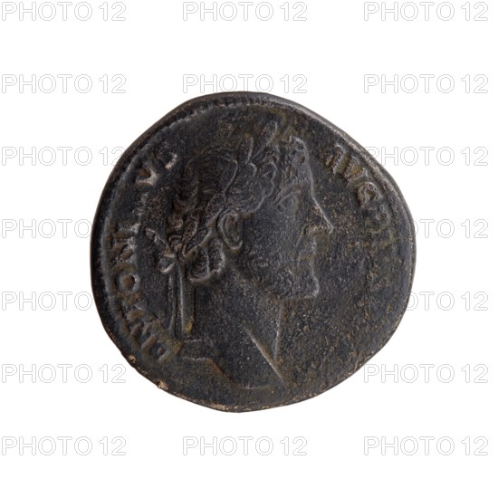 Sestertius of Antoninus Pius 86–161; Roman emperor 138–161. Obverse: Head of Antoninus Pius in a laurel wreath facing right; inscription ANTONINVS - AVG PIVS PP TR P. Reverse: Pax standing left; in his left hand a horn of plenty, in his lowered right hand a torch with which he ignites a weapon; inscription COS - II - II and field marks PAX - AVG / S - C. Date: 145–161. Place of origin: Rome, Roman Empire. Coin; diameter approx. 30.5–31.0 mm; weight 24.00 g; axis 345°., A round, worn coin shown against a white background with a profile of a person's head facing right; the coin's surface is dark brown to black with lighter brown and greenish patina in places, and it has textured, scratched areas and uneven edges.