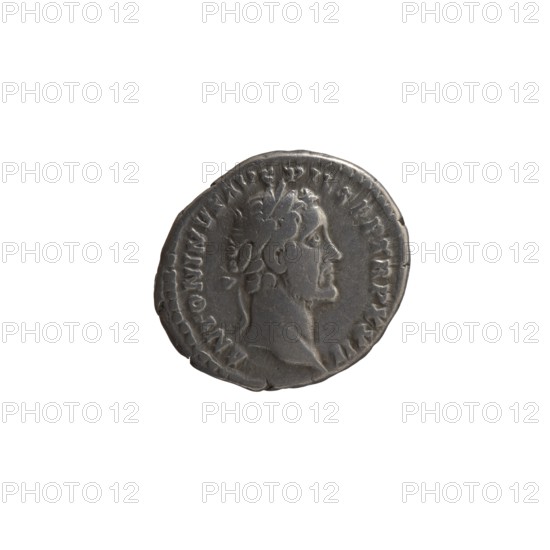 Denarius, Antoninus Pius 86–161; Roman emperor 138–161. Obverse: Head of Antoninus Pius with a laurel wreath facing right; legend ANTONINVS AVG PIVS PP TRP XXII. Reverse: Emperor in toga and veil standing left, holding a patera above a tripod in his right hand and a scroll in his left; legend VOTA SVSCE – PTA DEC III; episode COS IIII, 158–159. Iconography: emperor with veil, pateras, tripods, veils, scrolls. Roman Empire, Rome. Coin; diameter 16.5–18.0 mm, weight 3.20 g, axis 165°., A single circular coin with a raised profile of a male figure facing right, showing facial features, hair, and a laurel wreath; the coin surface has worn and textured areas with a slightly irregular rim; the colors visible are shades of gray and dark gray against a white background.