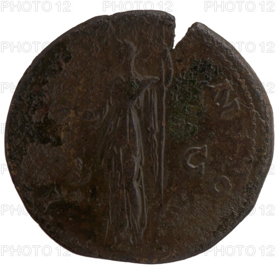 Sestertius, posthumous issue for Faustina the Elder 98–141; Roman empress 138–141, issued under Antoninus Pius 86–161; Roman emperor 138–161. Obverse: Bust of Faustina I in drapery facing right, DIVA FAVSTINA around. Reverse: Juno in veil and diadem standing left, holding a patera in her outstretched right hand and a long scepter in her left; inscription IV–NO all around, in SC fields. After 141, Roman Empire; Rome mint. Coin, diameter 32.0–34.0 mm, weight 21.55 g, axis 0°., A round, worn object with an uneven edge showing a chipped section at the top, featuring a raised, elongated human-like figure in the center with a long vertical element beside it; the surface is rough and pitted with irregular texture and small areas of mottling. The predominant colors are dark brown and black with spots of green patina and hints of lighter brown along worn edges; there are faint, shallow raised shapes around the right side and along the perimeter.