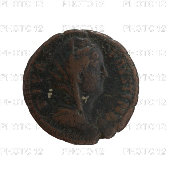 Dupondius/as; Faustina the Elder 98–141; Roman empress 138–141 posthumous; issuer: Antoninus Pius 86–161; Roman emperor 138–161. Bust of Faustina I in veil and drapery facing right, inscription DIVA • FAVSTINA around; reverse: Pietas stands left, stretches her right hand above an altar, holds a container in her left hand incense. Legend: AE TE•R•NITAS all around, in SC. Fields. After 141, Roman Empire; Rome mint. Coin: bronze, diameter 26.5 mm, weight 12.25 g, axis 345°., A round, worn coin-like object with a raised profile of a head in the center, showing a face in side view; the surface appears textured and irregular with areas of darker and lighter patina. The visible colors include brown, dark green, black, and small pale off-white spots. The edges are uneven and slightly chipped in places.