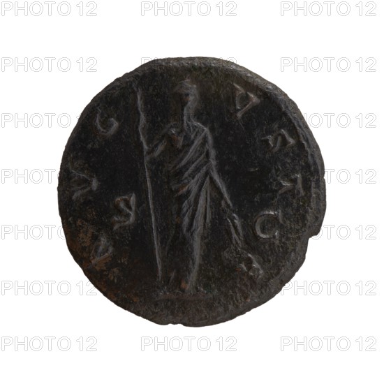 Dupondius/as; Faustina the Elder 98–141; Roman empress 138–141 posthumous; Antoninus Pius 86–161; Roman emperor 138–161 issuer. Bust of Faustina I in drapery facing right; legend DIVA FAV–STINA around. Reverse: Ceres standing right, holding a long torch in her right hand and ears of corn in her lowered left hand; legend A V G–V S T–A all around, in SC fields. Iconography: Ceres, ears of corn, torches. After 141, Roman Empire; Rome mint. Coin: bronze dupondius/as, diameter ~27.0–27.5 mm, weight 9.90 g, axis 180°., A circular dark brown and black worn coin showing a central standing figure draped in a long robe, holding a tall staff in one hand and a small object in the other; the figure's features and robe folds are visible as low-relief lines. The coin surface has areas of lighter brown corrosion and small rough patches around the edges, with a slightly irregular rim and a shallow raised border. The background around the figure is darker, creating slight contrast, and there are several...