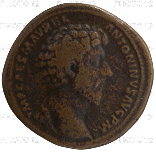 sestertius forgery, Marcus Aurelius 121–180; Roman emperor 161–180 issuer, Lucius Verus 130–169 - iconography; Marcus Aurelius - iconography; scrolls; handshake. Head of Marcus Aurelius uncovered, with drapery on the left shoulder, right. Obverse legend: IMP CAES M AVREL - ANTONINVS AVG PM. Reverse: Marcus Aurelius and Lucius Verus stand opposite and shake hands; Marcus Aurelius holds a scroll. Reverse legend: CONCORD AVGVSTOR TR P XVI; COS III; control marks SC. Date original: 161–162. Roman Empire. Rome. Counterfeit coin. Sestertius; weight 24.65 g; diameter 33.5–34.0 mm; axis 0°., A worn round coin with a raised portrait in profile near the center, showing worn facial features and curly hair; the surface displays irregular mottling and patina with areas of darker and lighter tones. The coin's rim is raised and shows a beaded inner edge, and there is visible wear around the edge. The predominant colors are brown and dark brown with patches of lighter brown and subtle hints of black.