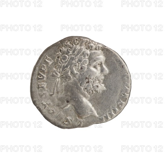 Denarius, Septimius Severus 146–211; Roman emperor 193–211 issuer. Obverse: Head of Septimius Severus in a laurel wreath facing right, inscription L SEPT SEV PE - RT AVG IMP IIII all around. Reverse: Minerva standing left, holding a spear in her right hand pointing forward and downward and a round shield in her left, inscription P M TR P II - COS II PP all around. Date: 194–195. Place: Rome, Roman Empire 27 BC–476. Type: coin. Diameter: 16.0–18.0 mm. Weight: 2.75 g. Axis: 180°., A circular metallic coin with a worn surface showing the right-facing profile of a bearded man with curly hair and a laurel or ribbon tying the hair at the back; the relief emphasizes facial features and textured hair and beard. The coin appears silver-gray with darker gray patina in recessed areas and a few small brownish spots. The rim is irregular and slightly dented, and the background around the coin is plain white.