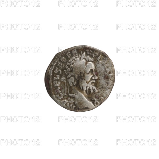 Denarius; Roman deities; Septimius Severus Roman emperor; 146–211 — iconography; Spes personification; 194; Roman Empire 27 BC–476 place of origin; Emesa mint; coin; diameter 17.0 mm; diameter 18.5 mm; weight 2.57 g, A round metallic object with a worn, textured surface and irregular edges, showing a raised profile of a bearded person facing right; the object displays patina and spots of darker discoloration with visible scratches and indentations, and the dominant colors visible are silver, gray, brown, and hints of reddish tones.