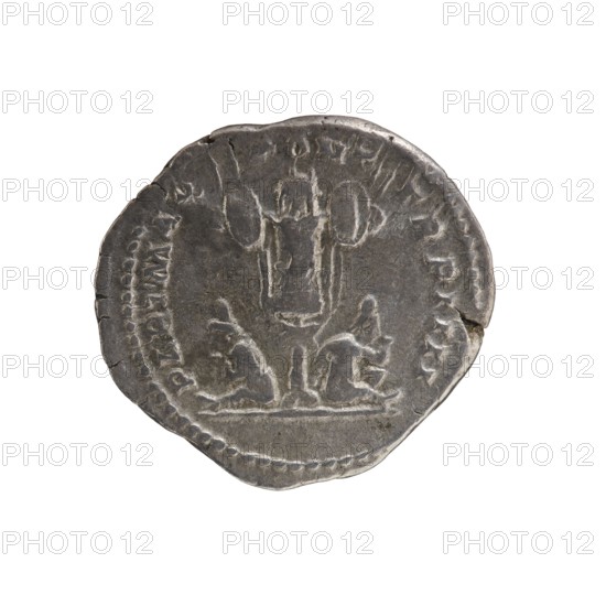 Denarius, Caracalla 188–217; Roman emperor 198–217. Obverse: ANTONINVS PIVS AVG, bust of young Caracalla in laurel wreath, cloak and armour facing right. Reverse: PART MAX PONT TR P IIII, trophy with seated bound prisoners beneath it. Iconography: trophy; prisoners at the feet of the trophy. Date: 201. Place of origin: Rome, Roman Empire 27 BC–476. Medium: coin. Diameter: 18.0–19.5 mm. Weight: 3.17 g., A round, worn coin with an uneven edge shown against a white background; the coin is metallic gray with darker and lighter gray areas, and features a central raised design that resembles a vertical pillar or column flanked by two rounded shapes above and two seated figures or shapes below, all rendered in low-relief; a beaded border follows the coin’s rim, and there are small chips and surface scratches visible around the edge.