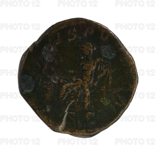 Sestertius of Severus Alexander Roman emperor 222–235, struck 222–228. Obverse: portrait/iconography of Severus Alexander ruler. Reverse: Salus personification. Roman Empire, Rome mint. Coin sestertius; diameters given 28.0 mm and 30.0 mm, weight 20.23 g., A worn round object with an uneven edge that appears to be a dark brown and black surface with patches of green and hints of reddish discoloration, showing a faint raised outline of a figure standing and holding an object, with irregular lighter brown and gray areas and small greenish-blue spots across the surface.