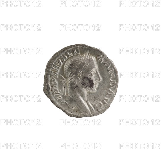 Denarius of Alexander Severus 208–235; Roman emperor 222–235. Obverse: portrait of Alexander Severus ruler. Reverse: Roman deity Mars. Subject/inscriptions reference imperial titles and hierarchy of power; iconography associated with Alexander Severus, dated 229. Roman Empire 27 BC–476, Rome mint. Coin; diameter approx. 18.0–18.5 mm; weight 2.90 g., A round metallic coin with a worn surface showing a raised profile of a person facing right, with short hair and a band tied at the back, visible facial features including an eye, nose, mouth, and chin, and some dark spots of discoloration on the cheek; the coin edge is irregular and slightly dented in places, and the visible colors are silver-gray with darker gray and black areas.