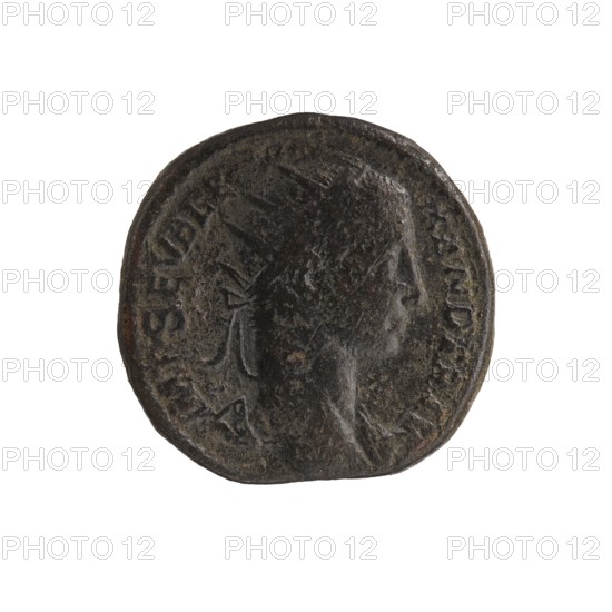 Dupondius; quadriga; Alexander Severus Roman emperor, 222–235 — iconography: emperor on quadriga; dated 229; Roman Empire 27 BC–476, Rome mint; coin; diameter 24.5–25.0 mm; weight 13.71 g, A round, worn dark brown to black coin with uneven edges, showing the raised profile of a person's head in three-quarter view, with visible hair and what appears to be a tied ribbon or band at the back of the head; the coin surface has areas of lighter brown and greenish patina, textured pitting, and a raised rim encircling the portrait.