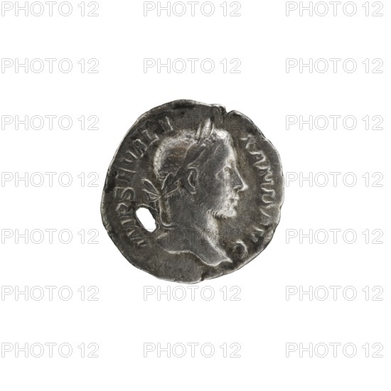 Denarius with hole, 228–231 CE, Roman Empire 27 BC–476, Rome mint; coin; diameter 18.0–19.0 mm; weight 2.15 g, A worn round metallic object with a textured surface and irregular edges showing shades of silver and gray, featuring a raised profile of a person's head in relief facing right with short hair and facial hair, a laurel or ribbon-like element at the back of the head, and a small oval hole near the left edge; the background around the object is white.