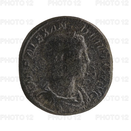 Sestertius; Roman deities; Alexander Severus Roman emperor, 222–235; obverse/reverse iconography: Sol mythology; date: 231; place: Rome, Roman Empire 27 BC–476; coin; diameter 29.0–30.0 mm; weight 20.11 g, A round, worn coin with a raised profile of a person's head facing right; the surface is textured and uneven with signs of wear. The coin appears dark with tones of black, dark brown, and hints of gray and greenish patina. There is a raised rim around the edge and faint raised decorative details surrounding the profile. The background is plain white.