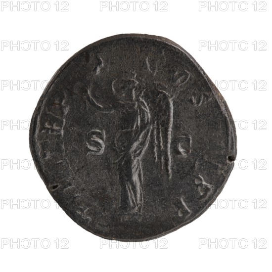 sestertius; Roman deities; Victoria; Alexander Severus Roman emperor, 222–235 — iconography; 231 CE, Rome; creator/mint role; Roman Empire 27 BC–476 — state; coin; diameter 28.0–30.0 mm; weight 16.86 g, A round dark coin with a worn surface showing a raised figure with wings standing in profile, the figure appears draped in a flowing garment and holding something near the shoulder; the coin has a rough edge with small nicks and irregularities and visible texture across its surface. The visible colors are dark gray, black, and subtle lighter gray highlights.