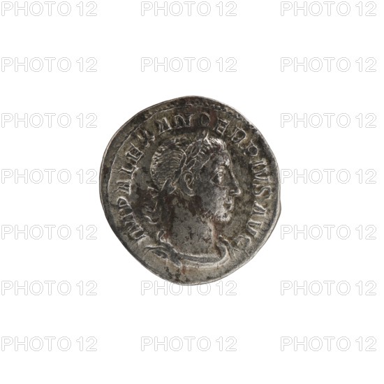 Denarius, Alexander Severus 208–235; Roman emperor 222–235. Issuer: Alexander Severus. Obverse iconography: Roman deities — Jupiter. Date: 231–235. Place of origin: Rome, Roman Empire 27 BC–476. Coin; diameter approx. 19.0–19.5 mm; weight 2.52 g., A worn circular metallic object with a raised profile of a person's head in relief, showing short hair and a laurel-like headband, surrounded by a raised rim and decorative raised elements around the edge; the surface shows areas of darker tarnish and lighter silver tones with some brownish spots, and the background is plain white.