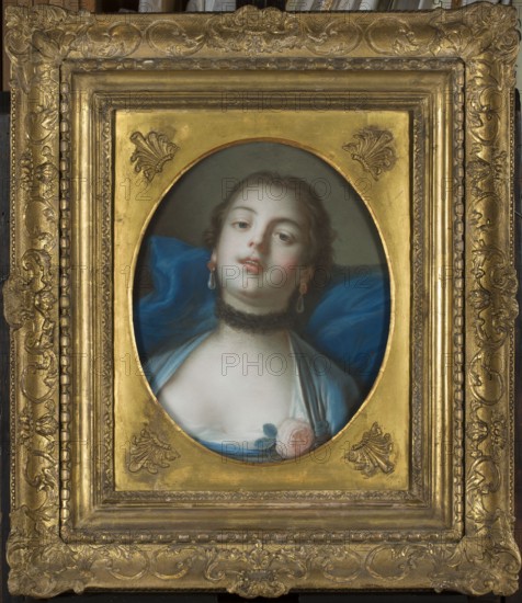 Allegory of Delight, copy after François Boucher, attributed to Louis François Marteau ca. 1715–1804 and after François Boucher 1703–1770; pastel, 1766–1767; height 44 cm, width 33 cm. Depicts an allegory voluptas with roses; 18th-century costume; women's portrait/dancer; French pastel style; portrait subject possibly Anna Binetti, iconography includes allegories and portraiture. Polish origin noted., A framed oval portrait of a woman set within an ornate gold frame; the frame has decorative carved patterns and a raised inner border with a gold finish. The portrait shows a woman with pale skin and dark hair pulled back, wearing drop earrings and a dark choker. She is draped in blue fabric with a lighter blue garment revealed at the neckline, and a pale pink rose with green leaves near her chest. The background behind her head is a muted neutral tone, and the blue drapery creates folds and shadows. Visible colors include gold, blue, pale pink, green, pale skin tones, dark brown, and mut...