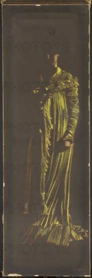 Yellow Lady, Kaufmann, Leon Kamir; 1872–1933, painter. 1909. Pastel on black paper. Height 137.5 cm, width 43.5 cm. Female portrait: standing woman in a long yellow shimmering satin dress. Artist drew a few lines with the sharp end of a sanguine red pastel crayon, building the figure’s volume with energetic strokes of lemon and warmer yellow pastel, placing highlights on the folds of the dress. Face, nose, and clenched hand outlined with smeared pinkish pastel; highlights and the white of the dress’s collar emphasized with touches of white. Kaufmann employed a drawing method using pastels that, by exploiting the color of the ground, achieves a painterly effect. The composition and treatment of fabric show continuity with his later oil painting Spring – Lady in the Garden by the Fountain 1926, which similarly emphasizes lights and reflections on silk with decisive brushstrokes., A tall, narrow portrait of a standing figure rendered mainly in shades of yellow and green against a dark bac...