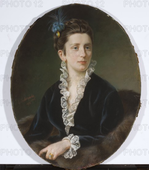 Portrait of Michalina Zaborowska, née Miaczynska, Dukszynska-Dukszta, Emilia 1847–1898 draughtsman, unknown provenance. Michalina Miaczynska 1848–1927 was the daughter of Witold and Klementyna née Glinska. Around 1870 she married Ambrozy Zaborowski 1833–1890; they had six children: Józef, Jan Nepomucen Boniface, Cyprian Jan Michal, Maria 1875–1953, Zygmunt Jan and Teresa. Their daughter Maria married Jan Franciszek Rucz 1852–1903 and later Michal Komorowski 1875–1950. Her great-granddaughter is Mathilde, Queen of the Belgians. The portrait is characterized by meticulous attention to detail: Dukszynska captures the subject's subtle beauty and the varied textures of the velvet and lace of the lady's dress and the fur wrapping around her. 1873; pastel; 72.5 × 57 cm., An oval portrait of a seated woman with pale skin and brown hair styled up and adorned with a blue feather and a small gold ornament, wearing a dark velvet dress with white lace ruffles at the collar and cuffs, a greenish tea...