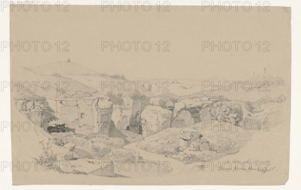 Villa di grotte di Cervara, Cervara di Roma, Campania, Italy; Arthur Blaschnik 1823–1918, draughtsman; drawing, 1855; subject: ruins, grottoes, landscapes; dimensions: 28.5 × 44.3 cm; German drawings; former German property; travels; Roman/Italian scenes., A pencil drawing on beige paper showing a rocky landscape with a group of cliffs and boulders in the middle foreground, surrounded by grassy slopes and low vegetation; a winding path or dry stream bed runs through the lower area toward the rocks; a few small shrubs and taller plants appear near the foreground edges; gentle rolling hills extend across the middle ground and into the distant horizon, with a solitary small tree or bush visible on a distant hill; the palette consists of beige paper with gray pencil lines and shading, creating tonal variations of gray on beige.
