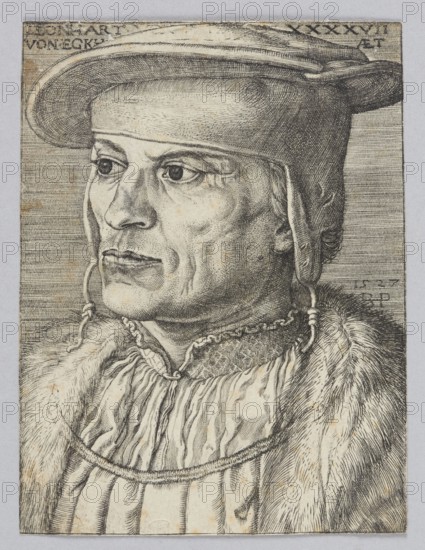 Portrait of Leonard Van Eckh by Barthel Beham 1502–1540, German graphic artist. Renaissance-era graphic print, costume design; male bust/portrait. 16th century. Height 10.3 cm, width 8 cm., A detailed monochrome portrait of a man shown from the shoulders up facing left, rendered with fine hatching and line work. He wears a brimmed hat with a rounded crown and a strap hanging down beside his face, and his hair is visible at the ear. His expression appears neutral with prominent eyes, a defined nose, and visible facial lines. He is dressed in layered garments including a textured fur or heavy outer collar and a pleated or gathered inner garment with a decorative neckline. The image palette is black and gray on a light background with subtle aged brownish spots throughout the paper.