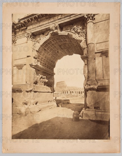 Rome. View from the Arch of Titus towards the Colosseum. Photographer: James Anderson 1813–1877. Publisher: Anderson Rome; photographic and publishing company. Subjects: Colosseum Rome, Arch of Titus Rome, Roman Forum. Themes: architecture, ancient architecture, Italian architecture, triumphal arches, ancient sculpture, nature photography. Medium/format: photographic print glued across the entire surface onto thick cardboard backing. Date: ca. 1880. Place of creation: Rome. Dimensions: photographic print height 52.5 cm, width 40.8 cm; cardboard height 62.3 cm, width 49.0 cm., The image shows a large stone archway with ornate carved details and a coffered underside, flanked by tall fluted columns and weathered blocks of masonry in shades of tan, beige, and brown; through the arch a distant stone amphitheater with arched openings is visible against a pale sky, and in the foreground a shadowed ground area contains a few worn stone bollards and rubble, with a solitary figure seated near th...