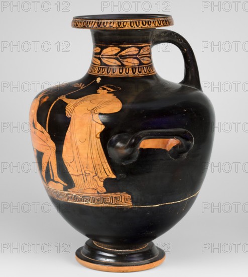 Red-figure hydria by the Amycus Painter, c. 420–400 BC (previously dated 420–410 BC). Greek pottery (Lucania). Red-figure hydria on a high, profiled foot; belly widens evenly toward broad, slightly sloping shoulders rising to a neck with a wide, profiled rim. Neck decorated with an ovoid at the base and a band of leaves; ovoid also borders the rim. Figurative scene on the belly and shoulders above a meander band: a naked youth seated on a rock at center; a man in profile turning back, leaning on a rock with his right hand and left hand on his left knee; the youth is slender with defined musculature. The ephebe is flanked by two draped female figures: left woman holds a mirror reflecting the youth; right woman holds a long leafy branch in her right hand. Both women hold their left hands near the hip and lean slightly toward the ephebe. Vessel type: hydria. Weight: 2.056 kg.