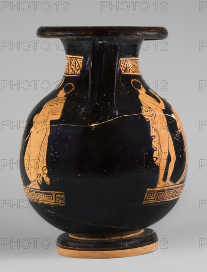Red-figure pelike depicting a woman putting on a pearl necklace; Southern Italic (Apulian) pottery, reddish-yellow clay, c. 380 BC. Pelike with a bulging belly, thick disc-shaped foot, ribbon-like handles; edge and underside of foot left the natural clay color. Neck decorated with a band of straight and inverted palmettes inscribed in a zigzag; below the belly scene a meander interrupted by horizontally filled rectangles. A: a woman seated on a klismos holding a necklace, wearing a finely pleated chiton, a cloak wrapped around her hips and knees, and a diadem; to her right a girl stands leaning against a small column; behind her a naked youth stands with a cloak over his left arm, holding a small disc or sphere in his right hand. B: two youths in cloaks flank a stele with a base seen in perspective, a wreath above the stele. Vessel type: pelike; height 29.3 cm, width 21.5 cm.