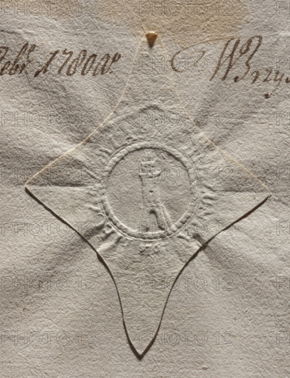 Round seal impression of the town of Biezunia, Masovian Voivodeship, Zuromin County. In the leafy rim, a tower widened at the bottom with an open gate, a superstructure at the top, and another one topped with battlements above it. In the rim, an illegible inscription, 1777, Poland.