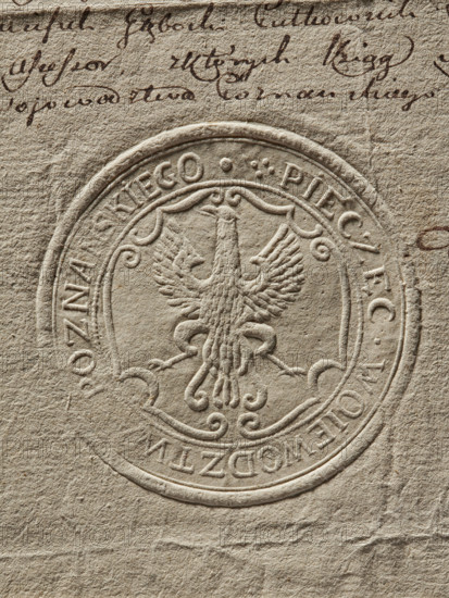 Round seal of the Poznan Voivodeship. Dry impression on a document; round land seal with an eagle without a crown in a decorative cartouche. Around the rim an inscription: 'SEAL OF THE POZNAN VOIVODESHIP.' 1792. Poland; Poznan Voivodeship (1314–1793). Seals with an eagle; city and land seals; official seals., The image shows a textured, beige-toned paper with an embossed circular seal featuring a stylized bird with outstretched wings at its center; the seal has ornate curved lines and decorative flourishes around the bird. The paper surface displays visible fibers and creases, and there is cursive handwriting in dark brown ink near the top edge. The overall colors visible are beige, tan, off-white, and dark brown.
