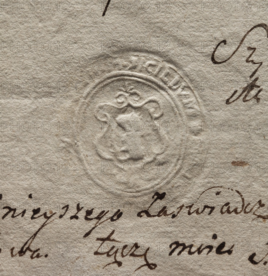 Oval wax seal impression of the town of Luków, Podlaskie Voivodeship. In the oval cartouche the Nalecz coat of arms with a jewel above the crown; illegible drawing in the decorative cartouche and illegible rim inscription. City seal and private seal, 1777, Luków, Poland.