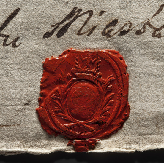 Oval wax seal impression of the town of Luków, Podlaskie Voivodeship. In the oval cartouche the Nalecz coat of arms with a jewel above the crown; illegible drawing in the decorative cartouche and illegible rim inscription. Oval seal impression, town and private seal, 1777, Poland.
